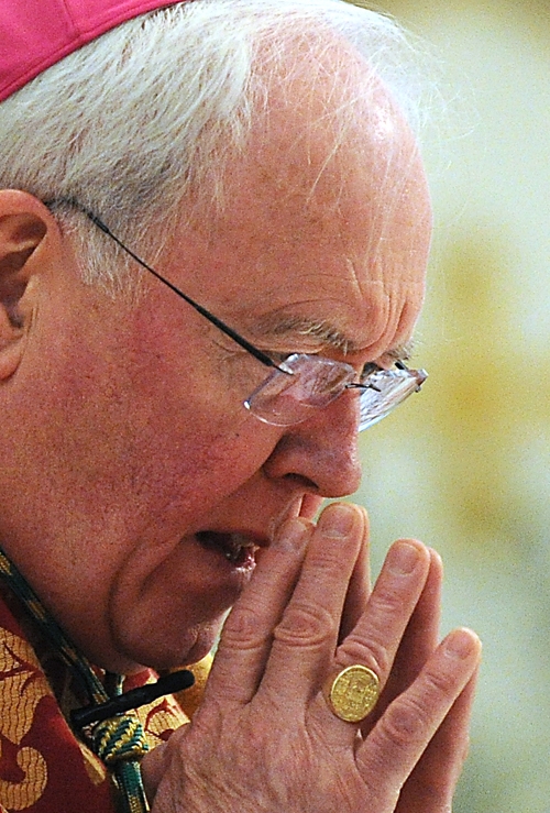 Bishop Richard Malone in silent pray at St Joseph Cathedral during Palm Sunday Mass. (Dan Cappellazzo/Staff Photographer)